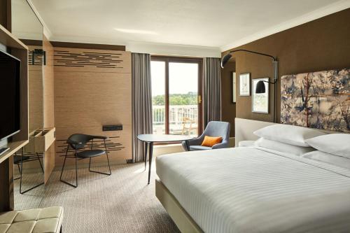 Habitación de hotel con cama, escritorio y TV. en London Marriott Hotel Regents Park, en Londres