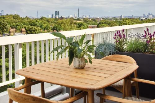 a wooden table on a balcony with a plant at London Marriott Hotel Regents Park in London