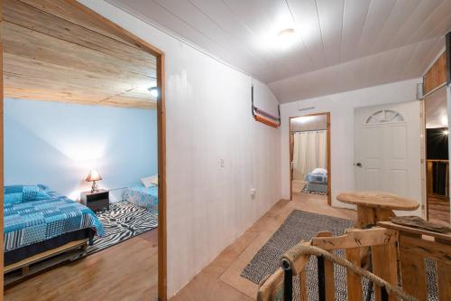 1 dormitorio con 1 cama y 1 mesa en una habitación en Cabaña de montaña Boquete, en Bajo Boquete