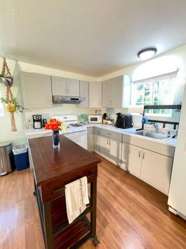 a kitchen with white cabinets and a wooden floor at Santa Barbara Serenity Large 1-bedroom Guest Apt. in Santa Barbara