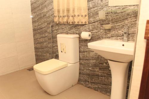 a bathroom with a toilet and a sink at Serenity Sigiri Resort in Sigiriya