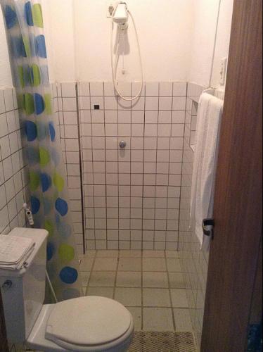 a small bathroom with a toilet and a shower at Chalé das Helicôneas - Suítes in Guaramiranga