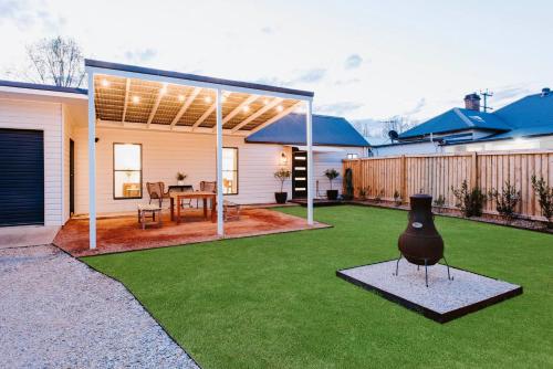 a yard with a house with a vase on the grass at 'The Fleetwood' Best Local Experience for Couples in Mudgee