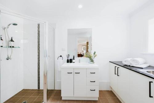 une salle de bain blanche avec une douche et un lavabo dans l'établissement 'The Fleetwood' Best Local Experience for Couples, à Mudgee