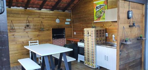 a kitchen with a table and a stove and a counter at Pousada Campus Rosa in Praia do Rosa