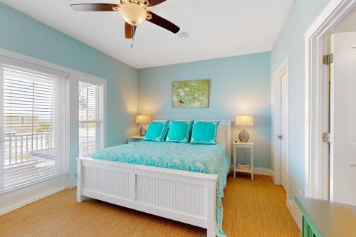 - une chambre avec des murs bleus et un lit avec des oreillers bleus dans l'établissement Gulfside Bliss, à Navarre