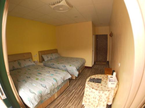 a small bedroom with two beds and a table at 崗好山莊 in Jianshi