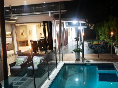 a house with a swimming pool at night at Sanctuary Palm Cove in Palm Cove