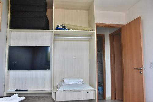Zimmer mit einem TV in einem weißen Schrank in der Unterkunft Cupe Beach Living - Royal 206 in Porto De Galinhas