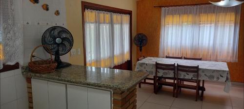 a kitchen with a table and a table and chairs at Morada BEACHE HOUSE 515 in Bertioga