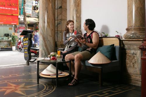 a man and a woman sitting on a couch at Media Central Hotel & Spa in Hanoi