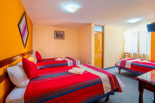 a hotel room with two beds and a table at Sonqo Killa del Colca in Chivay
