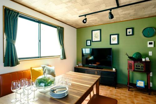 a dining room with a table and a television at Ikken House in Tokyo