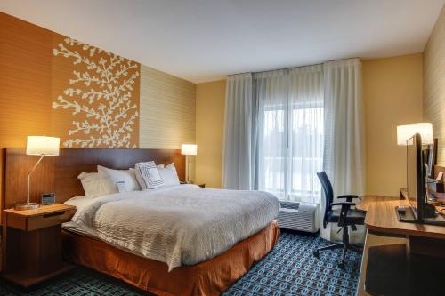 Cette chambre comprend un lit, un bureau et une télévision. dans l'établissement Fairfield Inn & Suites by Marriott Columbia, à Columbia