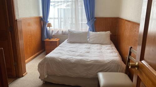 a small bedroom with a bed and a window at CHALET CHAPITAL Punta Arenas in Punta Arenas
