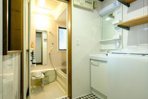 a small bathroom with a sink and a toilet at Ikken House in Tokyo
