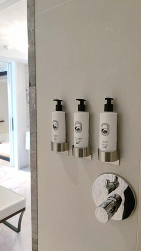 a bathroom with three soap dispensers on a wall at Mandarin Oriental, Taipei in Taipei