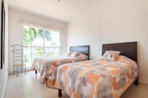 アカプルコにあるAcapulco Diamante. Casa de descansoのベッド2台と窓のある寝室