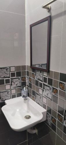 a bathroom with a white sink and a mirror at Aashiyana Home Stay, Arera Colony, Bhopal in Bhopal