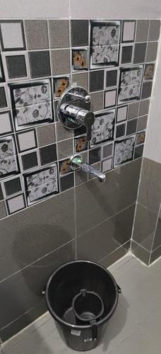 a bathroom with a black toilet in a room at Aashiyana Home Stay, Arera Colony, Bhopal in Bhopal