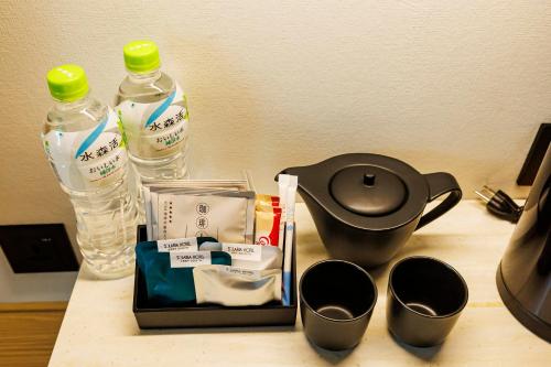 a counter with a tea pot and two bottles of water at Solaria Nishitetsu Hotel Taipei Ximen in Taipei