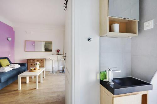um pequeno apartamento com uma cozinha e uma sala de estar em Cozy studio next to Gare de l'Est em Paris
