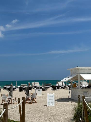 a beach with chairs and umbrellas and the ocean at Fontainebleau Miami Beach,Tresor in Miami Beach