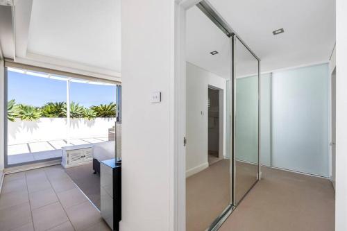 a glass shower in a room with a balcony at Waterview Penthouse - Cote D'Azur Resort, Nelson Bay in Nelson Bay