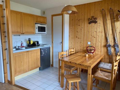 une cuisine avec une table en bois et une salle à manger dans l'établissement Studio cosy avec parking privatif aux Gets - FR-1-671-5, aux Gets