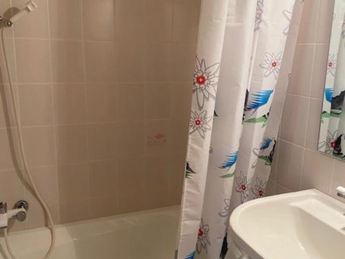 une salle de bain avec un rideau de douche et un lavabo dans l'établissement Studio cosy avec parking privatif aux Gets - FR-1-671-5, aux Gets