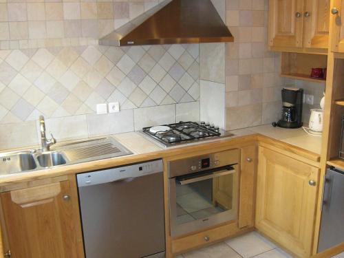 Il comprend une cuisine équipée d'une cuisinière. four supérieur à côté d'un évier dans l'établissement 3 chambres, parking privé, Wi-Fi, Les Gets - FR-1-671-8, aux Gets