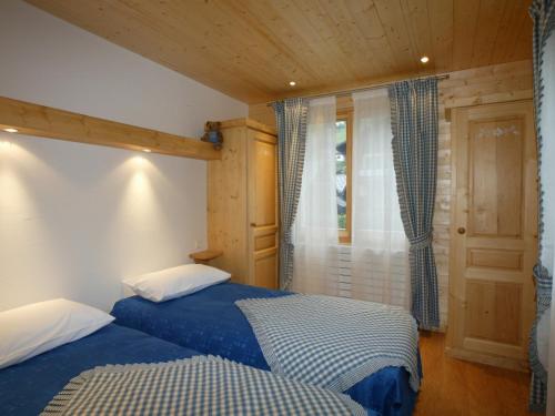 une chambre avec deux lits et une fenêtre dans l'établissement 3 chambres, parking privé, Wi-Fi, Les Gets - FR-1-671-8, aux Gets