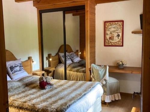 - une chambre avec 2 lits et un ours en peluche assis sur un lit dans l'établissement Chalet aux Gets avec Wi-Fi, cheminée, parking privatif, barbecue, proche pistes - FR-1-671-7, aux Gets