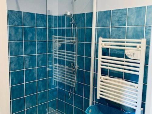 La salle de bains est pourvue de carrelage bleu et d'une douche avec du carrelage bleu. dans l'établissement Confortable T2 au Centre d'Amélie-les-Bains, proche thermes, très bien équipé, pour 2 personnes - FR-1-703-153, à Amélie-les-Bains-Palalda