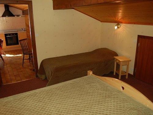 een kleine slaapkamer met 2 bedden en een keuken bij Appartement Les Gets, 2 pièces, 5 personnes - FR-1-671-15 in Les Gets