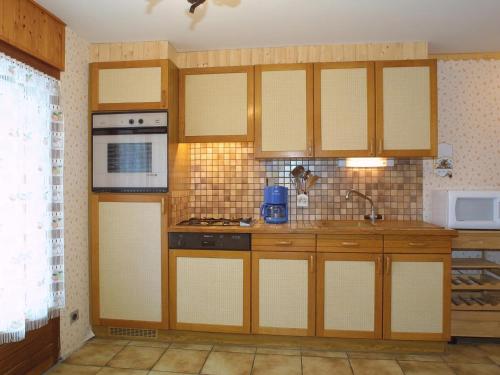 une cuisine avec des armoires en bois et un évier dans l'établissement Charmant Appt aux Gets: Terrasse, 4 pers, Proche Pistes et Centre, Animaux Bienvenus - FR-1-671-29, aux Gets