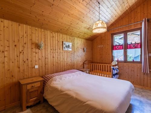 une chambre avec un lit dans une pièce en bois dans l'établissement Superbe Appartement 8 Pers, Proche Centre, 3 Chambres, Balcon, Casier à Ski, Wi-Fi, Animaux Admis - FR-1-671-31, aux Gets