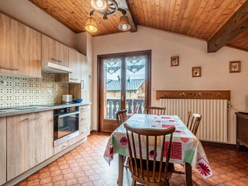 une cuisine avec une table et des chaises dans une pièce dans l'établissement Charmant appartement avec WiFi, parking et animaux admis - FR-1-671-77, aux Gets