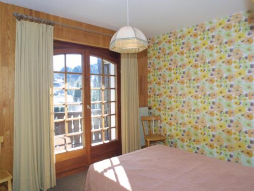 une chambre avec un lit et une fenêtre dans l'établissement Appartement familial avec balcon, proche télécabines et centre, garage, animaux admis - Les Gets - FR-1-671-41, aux Gets