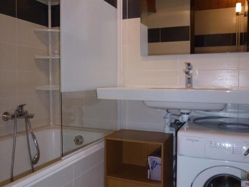 une salle de bain avec un lavabo et une machine à laver dans l'établissement Studio cosy aux Gets, proche des pistes, balcon, Wi-Fi, garage sécurisé, accepte les animaux - FR-1-671-42, aux Gets