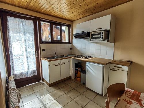 une petite cuisine avec un évier et un micro-ondes dans l'établissement Appartement cosy aux Gets - Idéal famille - Proche pistes - Animaux admis - FR-1-671-74, aux Gets