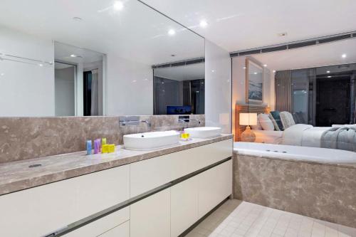 La salle de bains est pourvue de 2 lavabos et d'un grand miroir. dans l'établissement ULTIMATE OCEANFRONT - Soul Apartments - Self Contained, Privately Managed, à Gold Coast
