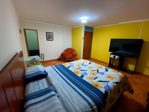 1 dormitorio con 1 cama y TV de pantalla plana en Hospedaje Gol, en Huancayo