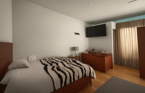 1 dormitorio con 1 cama y TV en la pared en Hospedaje Gol, en Huancayo