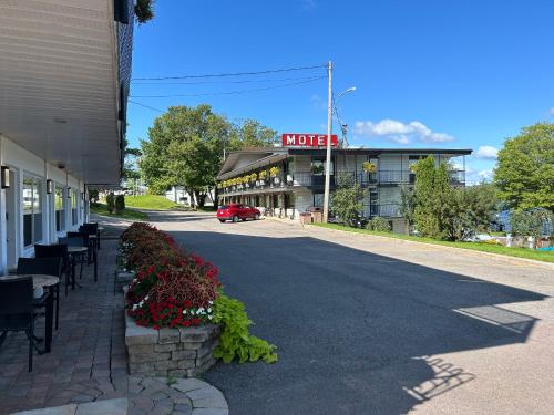 a building with a motel sign on a street at Motel Panoramique in Saguenay