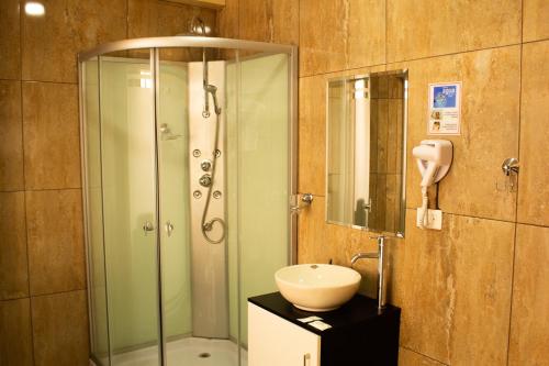 a bathroom with a glass shower and a sink at Hotel B&V in Huancayo