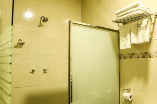 a shower with a glass door in a bathroom at Hotel B&V in Huancayo
