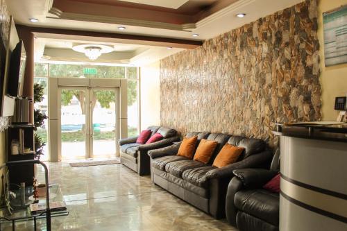 a living room with two leather couches in a room at Hotel B&V in Huancayo