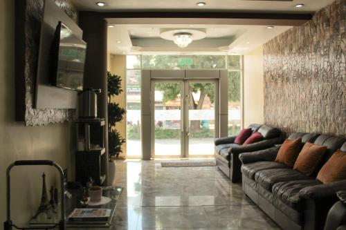 a living room with two couches and a large glass door at Hotel B&V in Huancayo