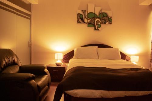 a bedroom with a large bed and a couch at Hotel B&V in Huancayo